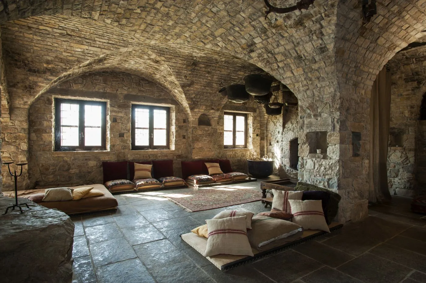 Vaulted stone lounge with cushions and natural light