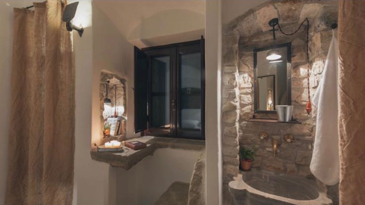 Stone-walled monastic bathroom with private shower